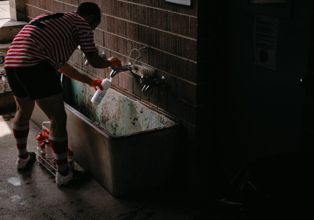 Installer fitting a stone-pattern bathtub in an unfinished bathroom