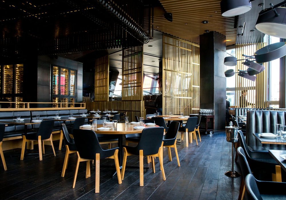 Warm modern bistro interior with pendant lights and set tables