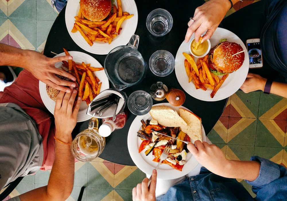 Friends sharing colourful plates around a table